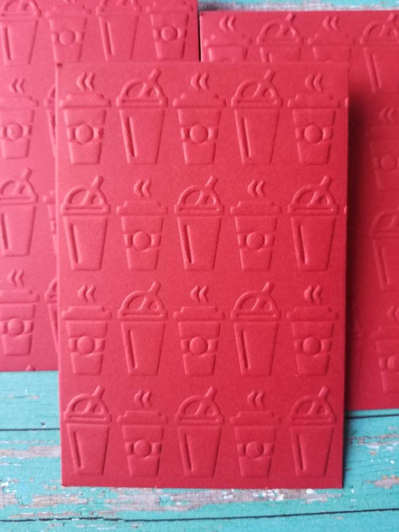 May include: Red card stock with a repeating pattern of embossed coffee cups. Each cup has a lid, straw, and steam coming from the top.