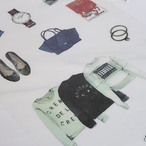 May include: Watercolor illustration featuring fashion items including a watch, handbag, shoes, rings, and sweaters. The sweaters have text that reads "Parental Advisory" and "Crème de la Crème". The items are in shades of black, white, and blue.