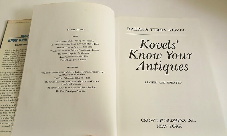 May include: Open book titled "Kovels' Know Your Antiques" by Ralph & Terry Kovel. The book is revised and updated, published by Crown Publishers, Inc. in New York. A second book is partially visible.