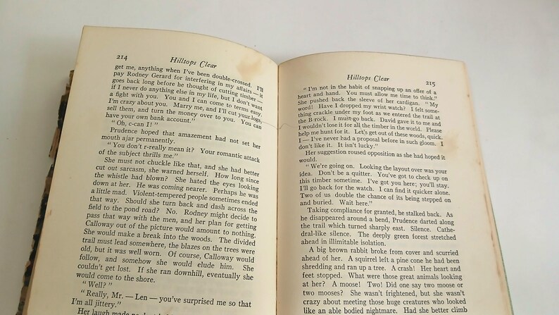 May include: An open book with text on aged, yellowed pages. The text is titled "Hilltops Clear" and is printed in black ink. The book is slightly open, revealing two pages of text.