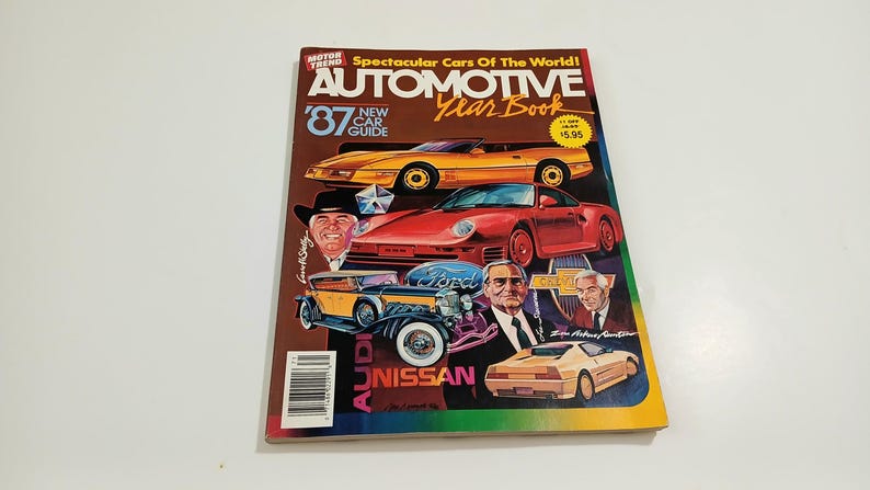 Puede incluir: Una revista Motor Trend Automotive Year Book de 1987 con un coche deportivo amarillo, un coche deportivo rojo, un coche antiguo amarillo y negro y un coche deportivo beige en la portada. La portada incluye el texto Spectacular Cars Of The World.