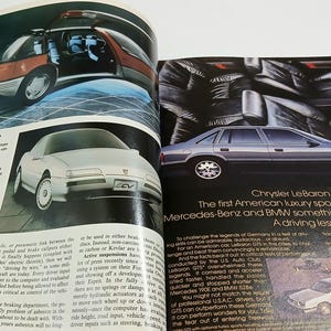 Puede incluir: Una p&aacute;gina doble de revista vintage con anuncios de autom&oacute;viles. La p&aacute;gina izquierda muestra un veh&iacute;culo conceptual Pontiac Trans Sport y un coche conceptual Pontiac Sunfire. La derecha presenta un sed&aacute;n Chrysler LeBaron GTS plateado.