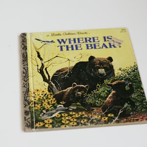 Op de afbeelding: Een vintage kinderboek met de titel "Waar is de beer?" met een gele kaft en illustraties van beren in een bosrijke omgeving.