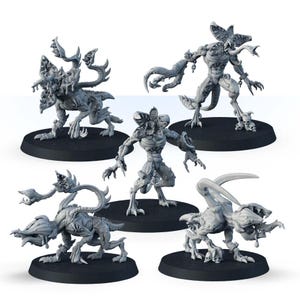 Op de afbeelding: Vijf grijze monsterbeeldjes met gedetailleerde texturen en dreigende poses worden gepresenteerd op zwarte cirkelvormige bases. De wezens hebben unieke, buitenaardse ontwerpen, met scherpe klauwen en meerdere aanhangsels.