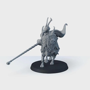 May include: A gray miniature fantasy figure of a creature with armor, horns, and a long staff. The figure stands on a black circular base. The armor has intricate details, and a shield with a face is attached to the creature's back.