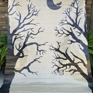 May include: A beige backdrop with two black silhouettes of bare trees and a crescent moon with a black bird silhouette on top.