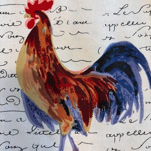 May include: A colorful rooster illustration on a white background with handwritten script. The rooster features red, orange, blue, and yellow hues. The script appears to be in black ink, adding a vintage aesthetic to the design.