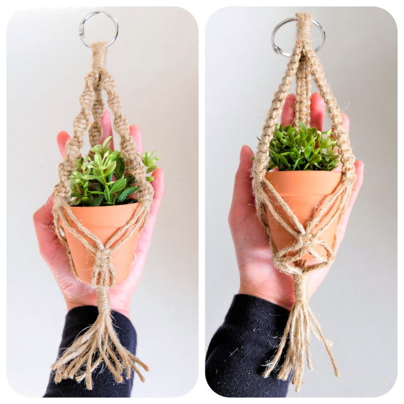 May include: A small terracotta pot containing a green plant is suspended from a macrame plant hanger crafted from natural jute twine. The hanger features a loop at the top for hanging and a tassel at the bottom.