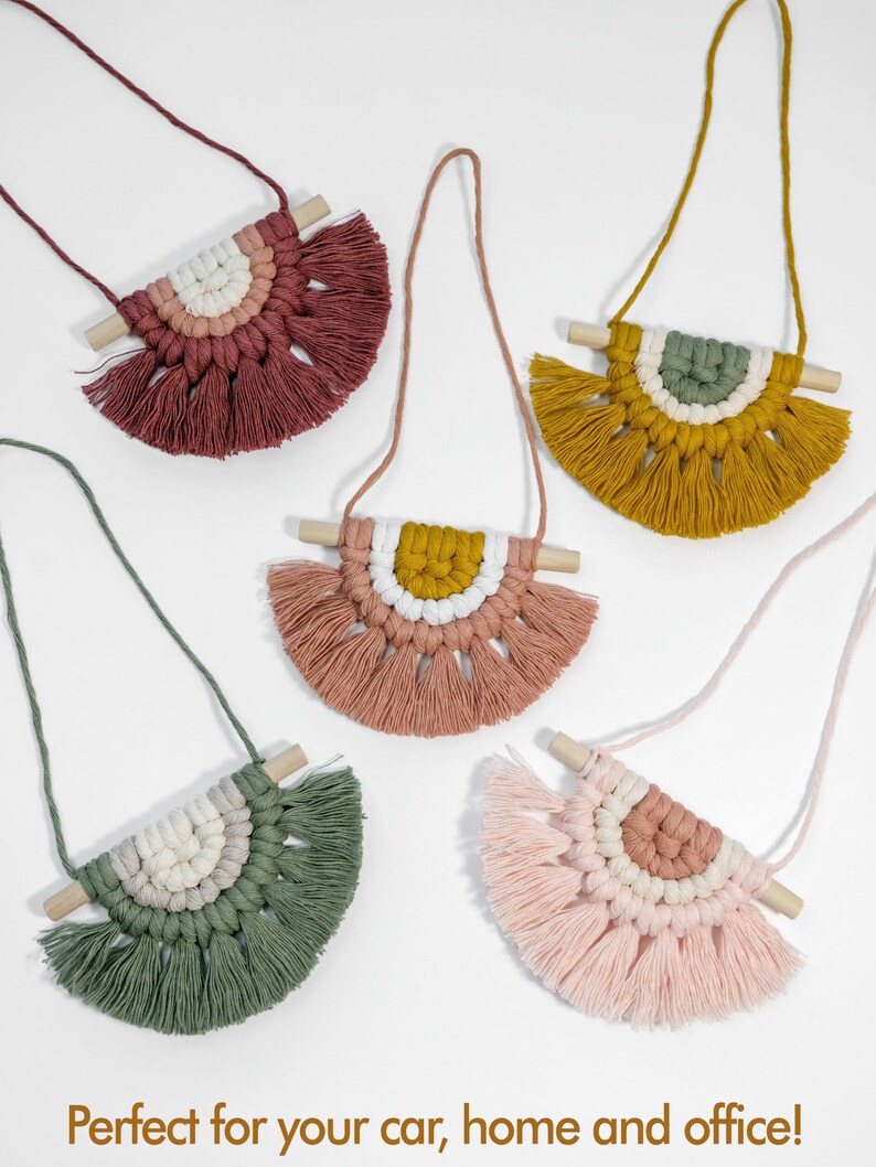 May include: Five colorful macrame wall hangings with wooden dowels and fringe. Each hanging features a different color combination of pink, green, yellow, and white.