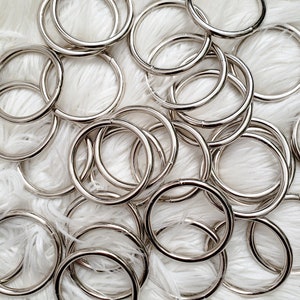 May include: A pile of silver metal rings, likely for attaching to bags or other items.