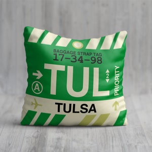 May include: Green and white luggage tag with the text "TUL" and "TULSA" and the baggage strap tag number "17-34-98".
