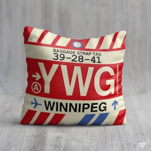 May include: A red and white luggage tag with the text "BAGGAGE STRAP TAG 39-28-41 YWG WINNIPEG" and an arrow pointing to the right. The tag has a blue circle with a white dot in the center.