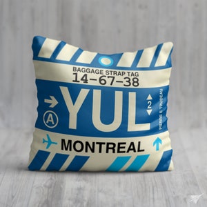 May include: A white and blue luggage tag with the text "BAGGAGE STRAP TAG 14-67-38 YUL MONTREAL" and a blue airplane icon. The tag also has a blue circle with a white arrow pointing to the right and the letter "A" inside. There is a blue arrow pointing up with the number "2" next to it and the text "PIERRE E TRUDEAU" on the right side of the tag.