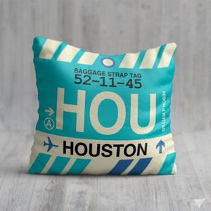 May include: A blue and white luggage tag with the text "HOU" and "HOUSTON" and the baggage strap tag number "52-11-45".