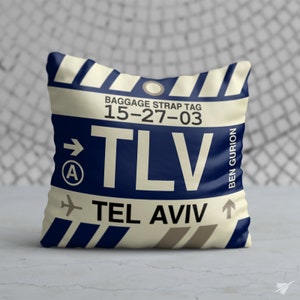 May include: Square cushion featuring a cream-coloured background with a navy blue baggage tag design. The tag reads "BAGGAGE STRAP TAG 15-27-03" and "TLV TEL AVIV BEN GURION". The cushion has a vintage travel theme.