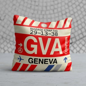 May include: Red and white luggage tag with the text "BAGGAGE STRAP TAG 29-13-38 GVA GENEVA" and an arrow pointing to the right. The tag also has a small airplane icon and the word "COINTRIN" written vertically.