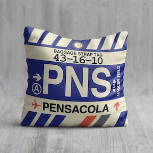 May include: A white pillow with a blue and red luggage tag design. The tag says "PNS" and "PENSACOLA" with the airport code "43-16-10".