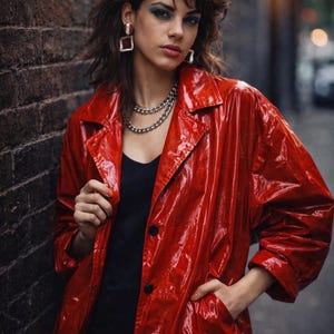 May include: A glossy red trench coat with a classic collar and button closure. The coat is worn over a black top and paired with silver jewelry. The image has a retro, edgy aesthetic.