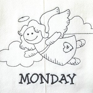 Pode incluir: Tecido branco com um desenho bordado a preto de um anjo sorridente com aur&eacute;ola, asas e um remendo em forma de cora&ccedil;&atilde;o no vestido. A palavra "MONDAY" est&aacute; bordada a preto por baixo.