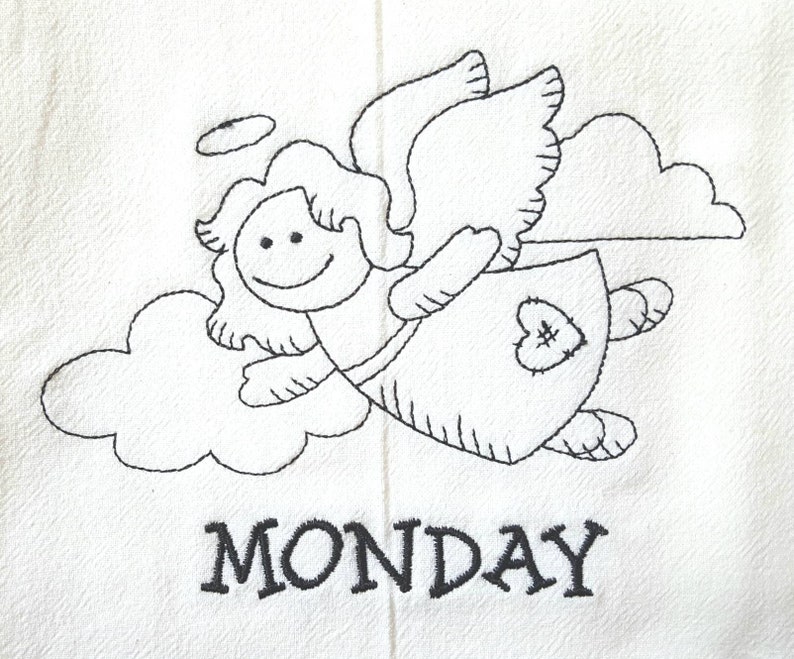 Pode incluir: Tecido branco com um desenho bordado a preto de um anjo sorridente com aur&eacute;ola, asas e um remendo em forma de cora&ccedil;&atilde;o no vestido. A palavra "MONDAY" est&aacute; bordada a preto por baixo.