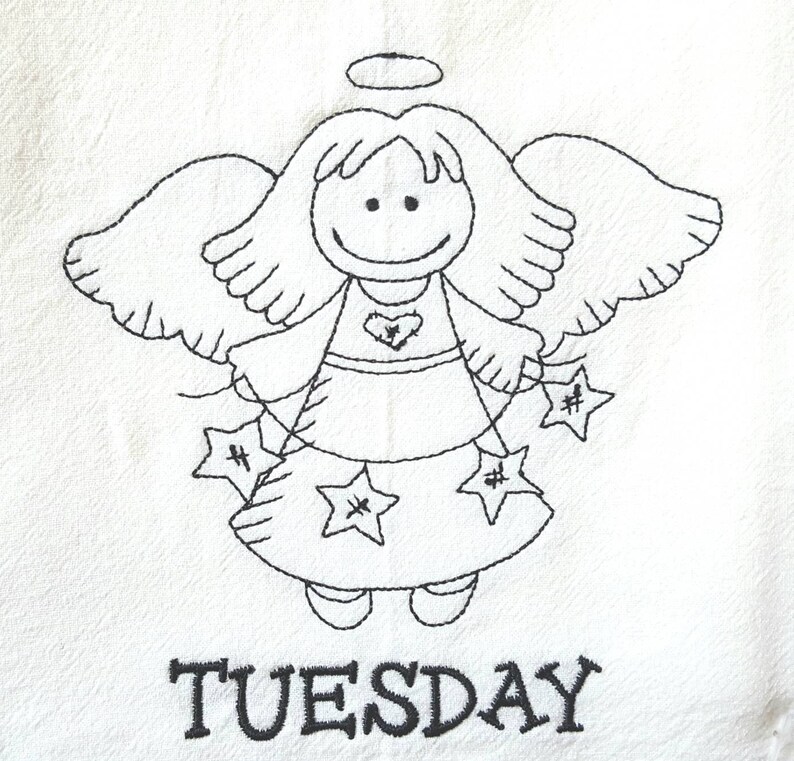Pode incluir: Tecido branco com um desenho de anjo bordado em preto. O anjo tem um halo, asas e segura ornamentos em forma de estrela. A palavra "TUESDAY" est&aacute; bordada abaixo.