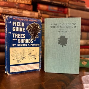 Könnte beinhalten: Zwei Vintage-Feldführer über Bäume und Sträucher. Das Buch links ist blau mit dem Titel "A Field Guide to Trees and Shrubs" und dem Namen des Autors. Das Buch rechts ist hellblau mit dem Titel "A Field Guide to Trees and Shrubs".