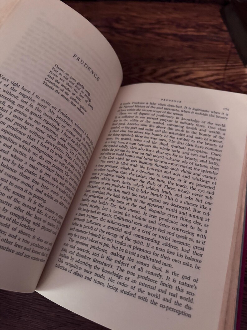 May include: An open book with the title "PRUDENCE" at the top. The pages are filled with printed text, with a focus on the text and the book's content. The book is on a dark wooden surface.