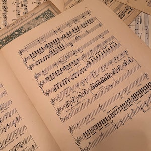 May include: Close-up of a sheet of music with handwritten notes and musical notation. The music is titled "Dreams" and includes the lyrics "And the stars shall be of the moons and the great songs sung in the deep."