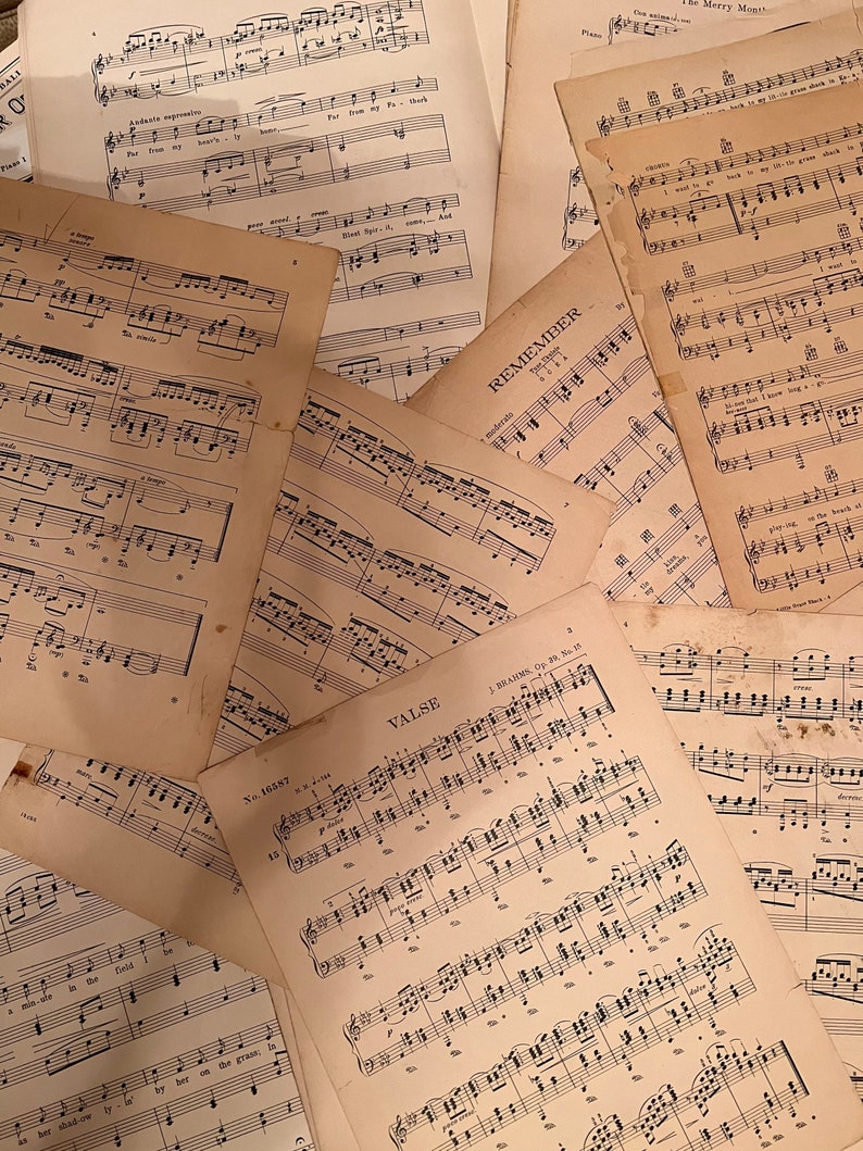May include: A collection of vintage sheet music, including pieces titled "Remember" and "Valse". The music is printed on yellowed paper with black ink.