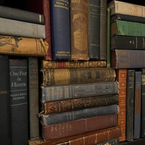 May include: A bookshelf filled with a variety of old, leather-bound books. The books are arranged in rows and columns, and many of them have titles and author names visible. The books are mostly brown, black, and red in color.
