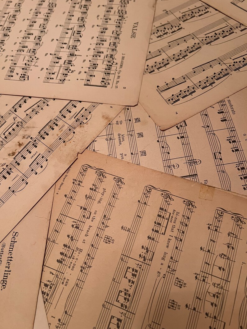 May include: A stack of vintage sheet music with musical notes printed on the pages. The top sheet has the title "VALSE" and the composer's name "J. BRAHMS, Op. 30, No. 15".
