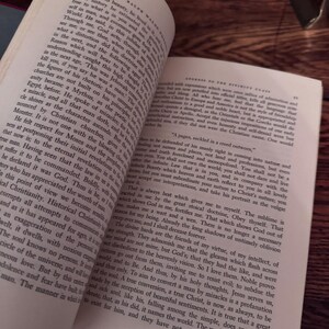 May include: Open book with text on aged paper, angled to show both pages. The text is in English, with visible page numbers and a vintage aesthetic. The book's pages are yellowed, suggesting age and use.