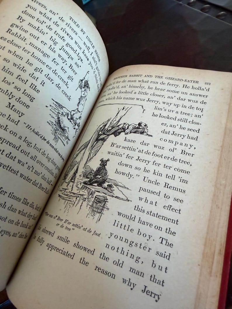 May include: An open book with aged, yellowed pages. The text is in black ink, with illustrations of figures and scenes. The book is titled "Brother Rabbit and the Gizzard-Eater" and "Told by Uncle Remus". The book's binding is red.