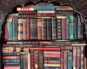 May include: A wooden bookshelf filled with rows of vintage hardcover books. The books are mostly brown, red, and blue with gold lettering. The bookshelf has a carved wooden frame.