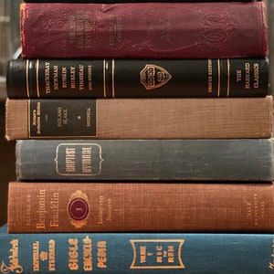 May include: A stack of vintage hardcover books with various titles and authors. The books are arranged in a vertical stack, with the top book being a black hardcover with gold lettering. The bottom book is a green hardcover with gold lettering. The books are all in good condition and appear to be well-loved.