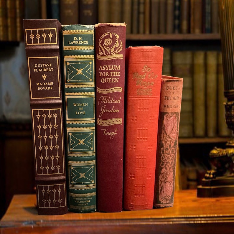 May include: Five vintage hardcover books with gold lettering on the spines. The books are arranged vertically from left to right. The titles are "Madame Bovary", "Women in Love", "Asylum for the Queen", "So Red the Rose", and "Queen of the Air".