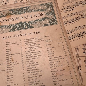 May include: A vintage sheet music book with a green and gold decorative border. The title is "Songs & Ballads" by Mary Turner Salter. The book lists a variety of songs with their key signatures and tempos.