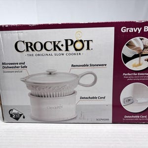 May include: A rectangular product box for a Crock-Pot gravy boat. The white and maroon packaging displays the appliance, which features a removable stoneware vessel with a lid, a handle, and a base. It holds 2 1/4 cups and includes a detachable cord.