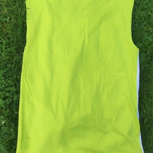 May include: A sleeveless shirt in a bright lime green color. The shirt has a plain design and is made of a soft, comfortable fabric.
