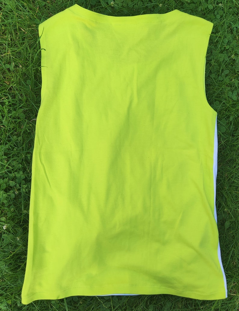 May include: A sleeveless shirt in a bright lime green color. The shirt has a plain design and is made of a soft, comfortable fabric.