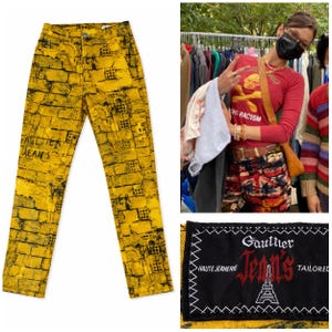 Puede incluir: Vaqueros amarillos con un patrón de ladrillos y detalles en negro. Los vaqueros presentan el texto "GAULTIER JEANS" y una etiqueta negra con el nombre de la marca y un gráfico de la Torre Eiffel. Una declaración de moda única.