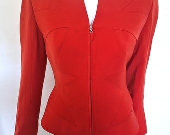 May include: A red blazer with a zipper closure and a unique geometric design on the front.