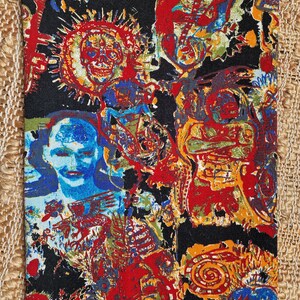 May include: A black fabric with a colorful, abstract pattern. The pattern features various shapes, lines, and figures in shades of red, blue, yellow, green, and orange.