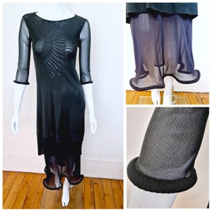 Puede incluir: Vestido negro de malla con un dobladillo festoneado. El vestido está hecho de una tela transparente y tiene una silueta ajustada.