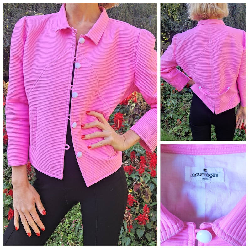 May include: A pink, ribbed, cropped jacket with a white button closure and a white label that reads "Courreges Paris".