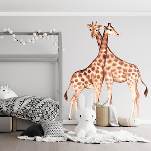 May include: A child's bedroom with a gray bed frame, bedding with a black and white chevron pattern, and a large giraffe wall decal. A white bunny lamp and decorative baskets add to the room's theme. A string of white globe lights hangs above the bed.
