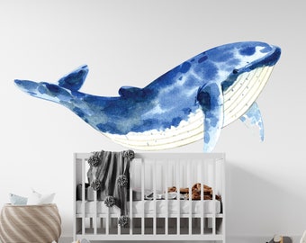 May include: A watercolor illustration of a blue whale with white accents, perfect for a nursery or child's room.