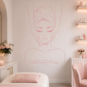 May include: A pink line art wall decal featuring a person with eyes closed, wrapped in a towel, receiving a facial massage. The minimalist illustration depicts the head, shoulders, and hands performing the massage, applied to a light wall.