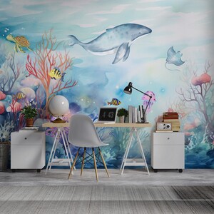 May include: A watercolor mural depicting an underwater scene with a blue whale, coral, fish, a turtle, and a stingray. The mural is on a wall in a home office with a desk, chair, and other decor.