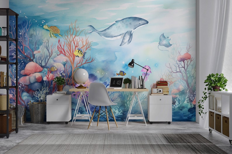May include: A watercolor mural depicting an underwater scene with a blue whale, coral, fish, a turtle, and a stingray. The mural is on a wall in a home office with a desk, chair, and other decor.
